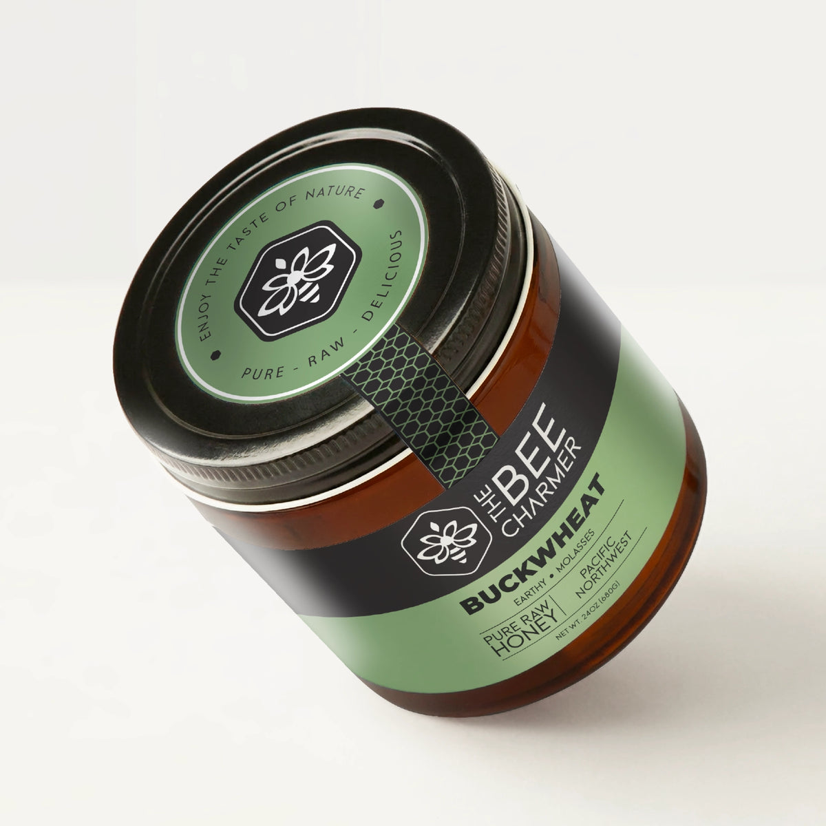 Pure raw Buckwheat Honey in a signature Bee Charmer branded 24oz wide-mouth glass jar showing the top of the jar label.