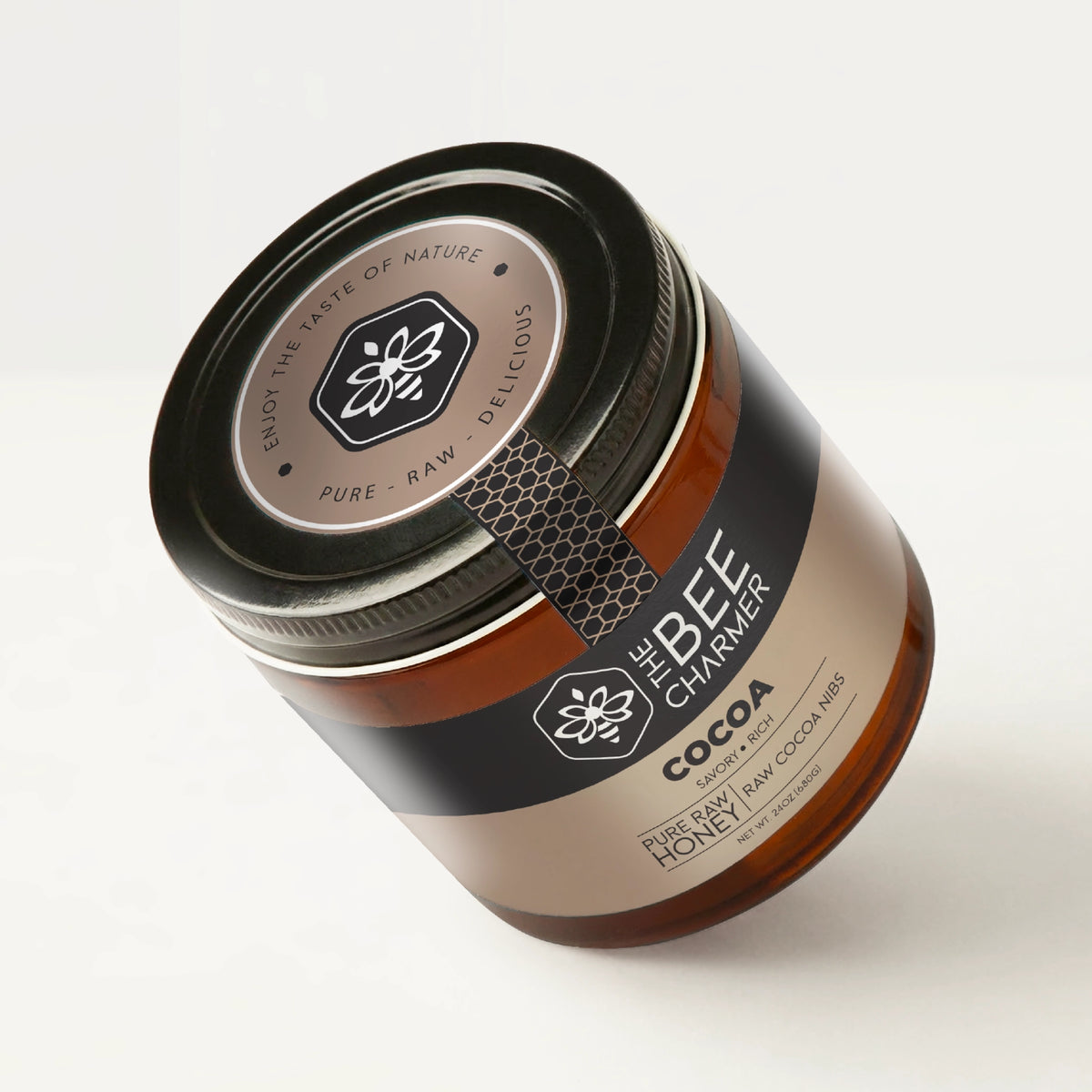 Cocoa Honey in a signature Bee Charmer branded 24oz wide-mouth glass jar showing the top of the jar label.