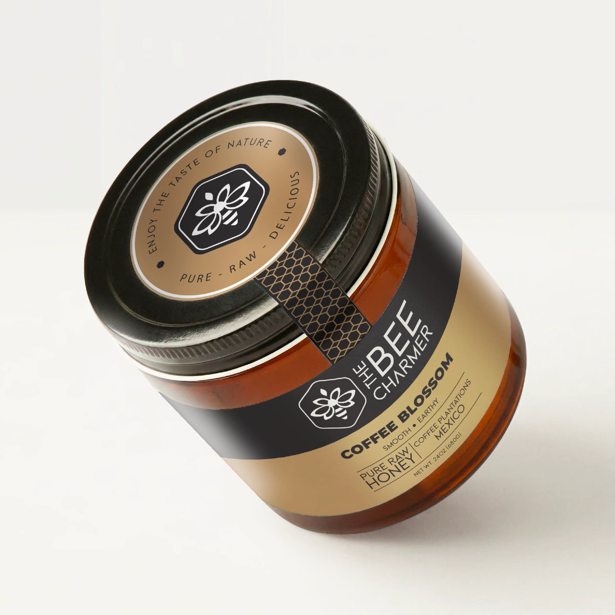 Pure raw Coffee Blossom Honey in a signature Bee Charmer branded 24oz wide-mouth glass jar showing the top of the jar label.