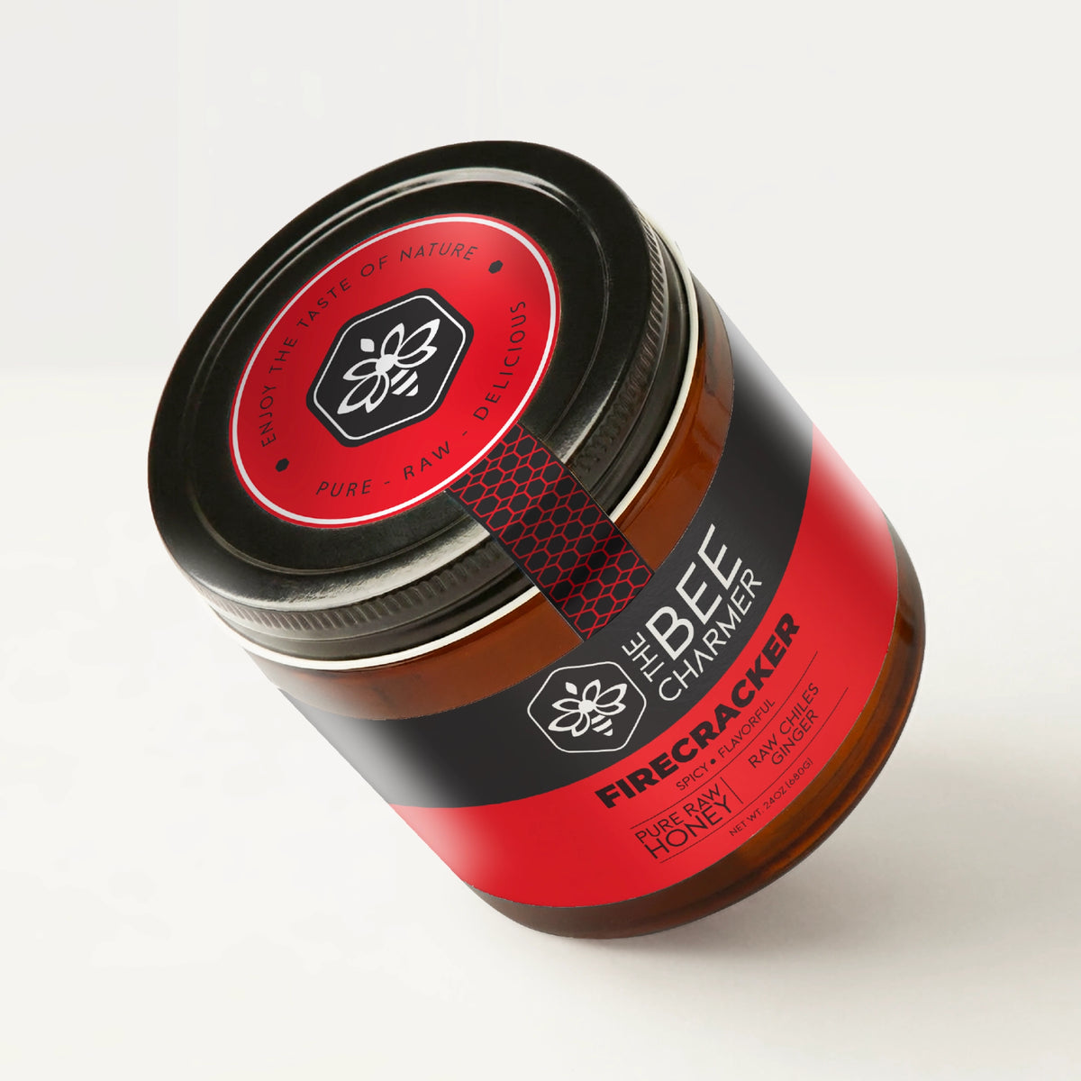 Chile and ginger-infused Firecracker Hot Honey in a signature Bee Charmer branded 24oz wide-mouth glass jar showing the top of the jar label.