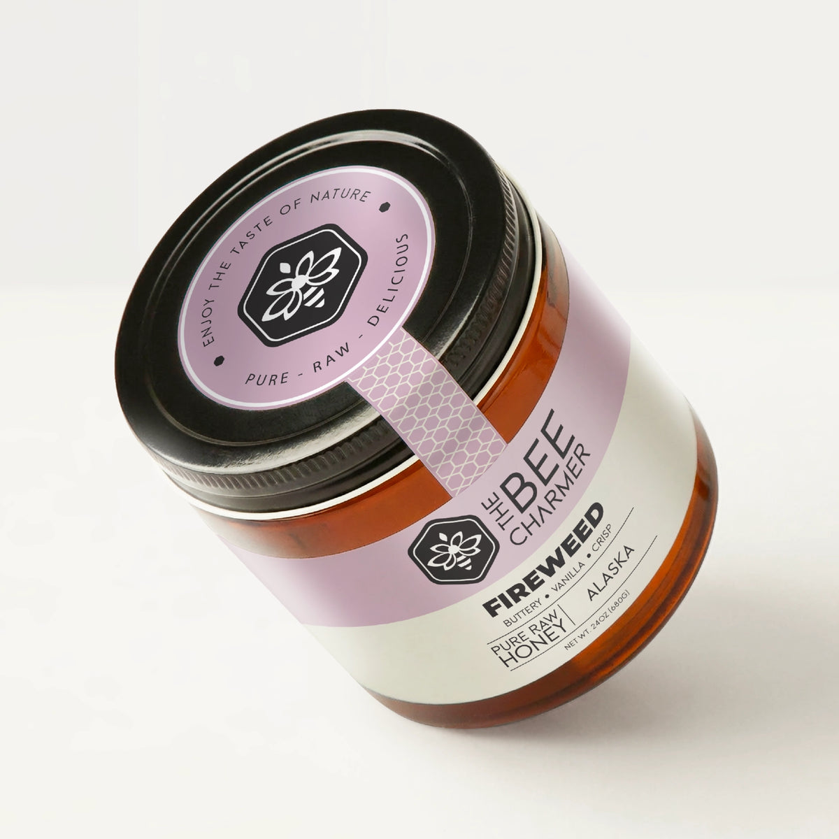 Pure raw Fireweed honey in a signature Bee Charmer branded 24oz wide-mouth glass jar showing the top of the jar label.