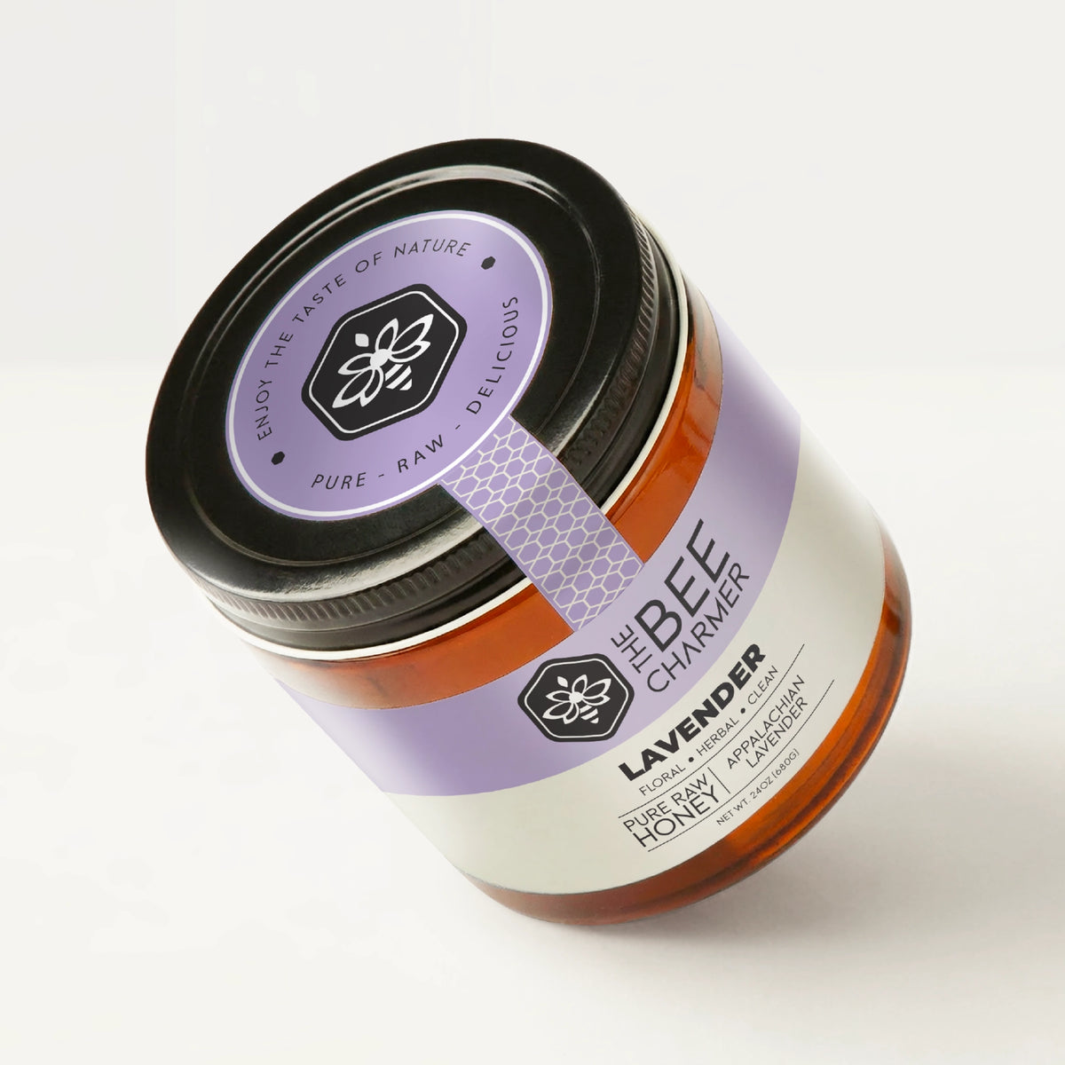Lavender Honey in a signature Bee Charmer branded 24oz wide-mouth glass jar showing the top of the jar label.
