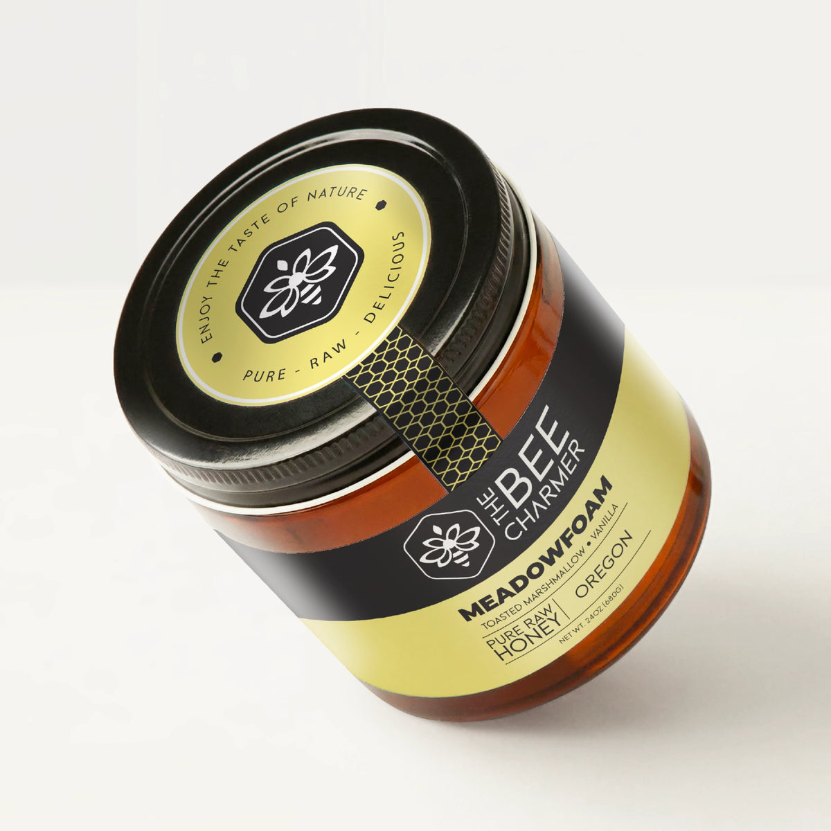 Pure raw Meadowfoam Honey in a signature Bee Charmer branded 24oz wide-mouth glass jar showing the top of the jar label.