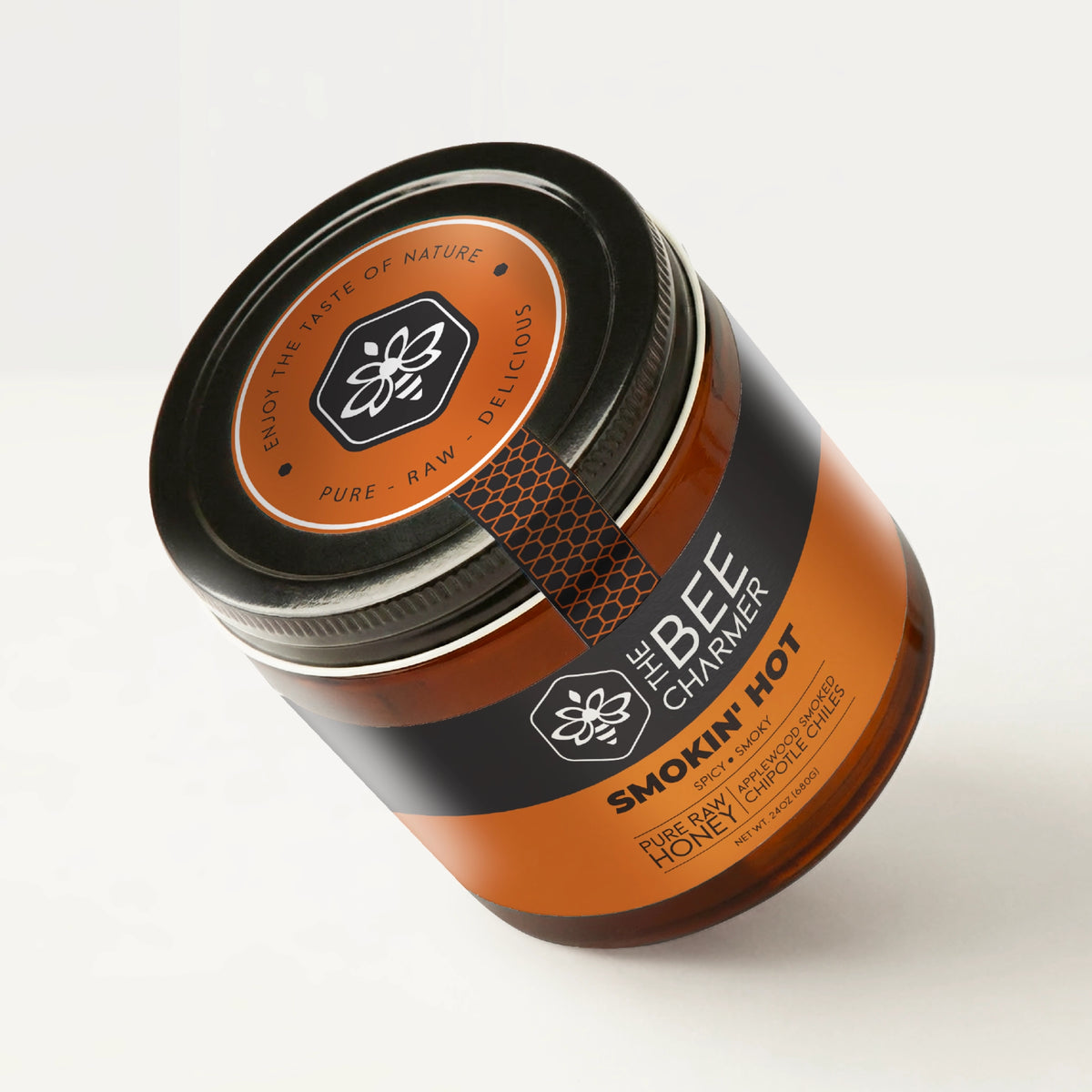 Applewood-smoked chipotle chile-infused Smokin Hot Honey in a signature Bee Charmer branded 24oz wide-mouth glass jar showing the top of the jar label.