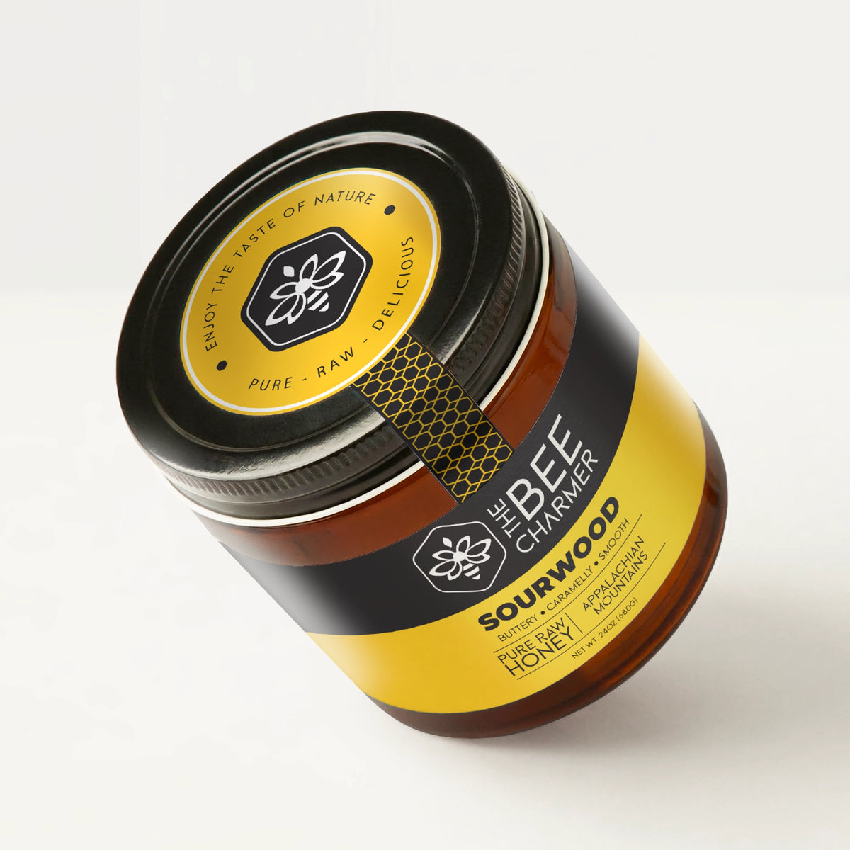 Pure raw Sourwood Honey in a signature Bee Charmer branded 24oz wide-mouth glass jar showing the top of the jar label.