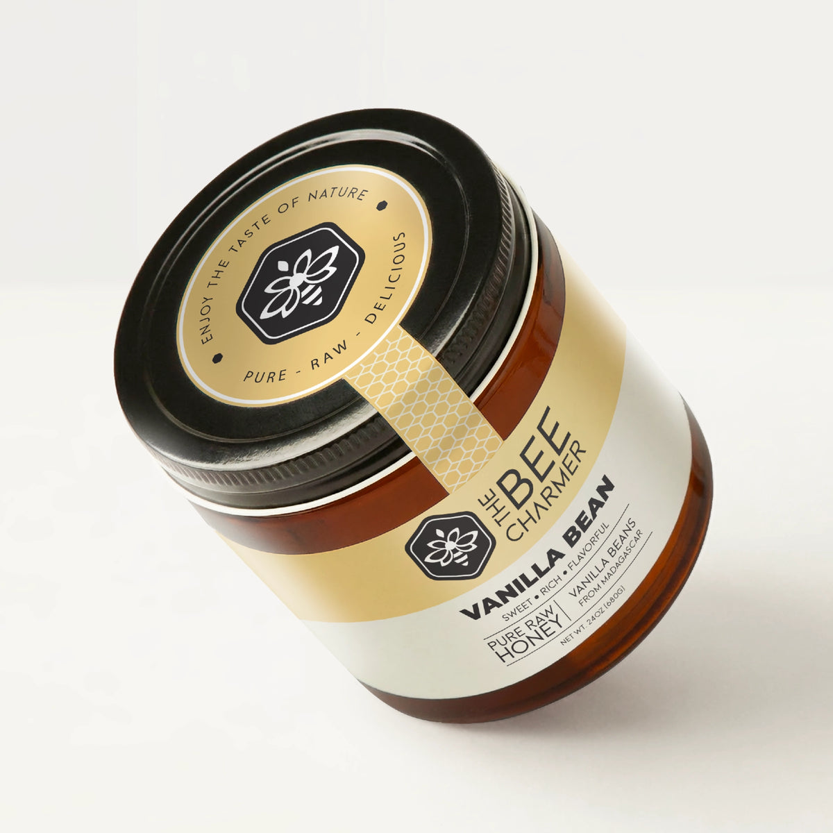 Vanilla Bean Honey in a signature Bee Charmer branded 24oz wide-mouth glass jar showing the top of the jar label.