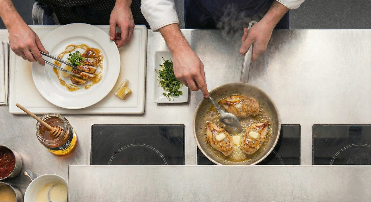 Two restaurant chefs cooking in a professional kitchen using The Bee Charmer's honey.