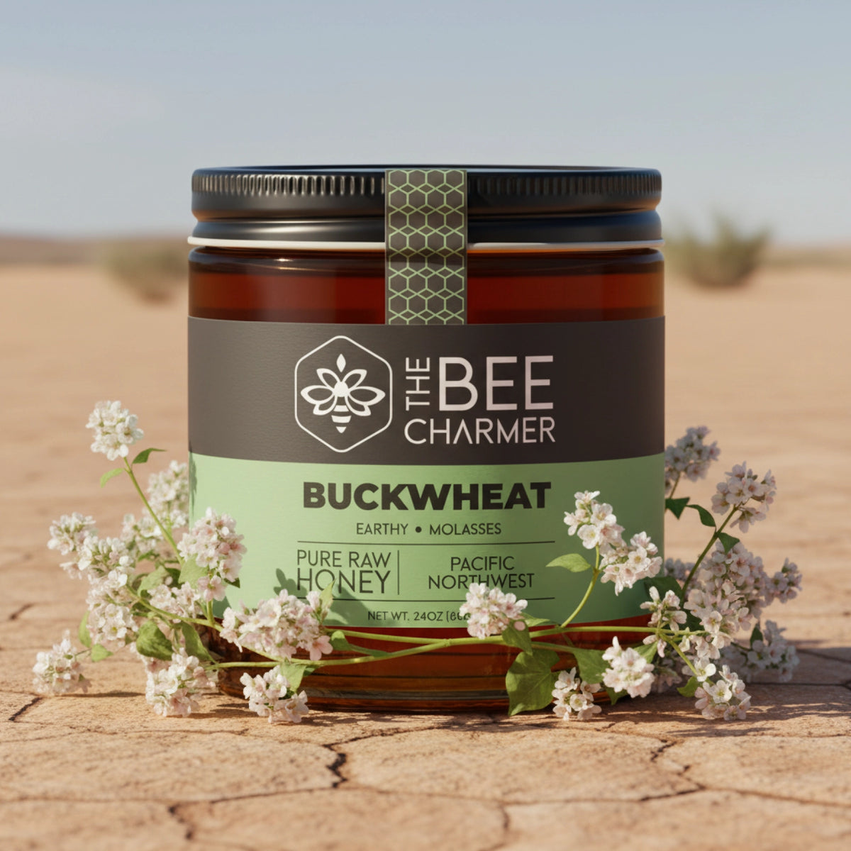 The Bee Charmer 24oz Buckwheat Honey jar shown with buckwheat plant blossoms.